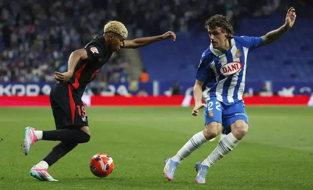 Barcelona's Lamine Yamal, left, runs with the ball past Espanyol's Carlos Romero during a Spanish La Liga soccer match between Barcelona and Espanyol at Lluis Companys Olympic Stadium in Barcelona, Spain, Thursday, May 15, 2025. (AP Photo/Joan Monfort)
