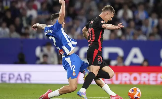 Espanyol's Roberto Fernandez tackles Barcelona's Dani Olmo during a Spanish La Liga soccer match between Espanyol and Barcelona in Barcelona, Spain, Thursday, May 15, 2025. (AP Photo/Jose Breton)