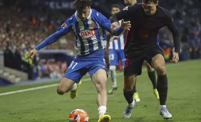 Espanyol's Antoniu Roca, left, fights for the ball with Barcelona's Andreas Christensen during a Spanish La Liga soccer match between Barcelona and Espanyol at Lluis Companys Olympic Stadium in Barcelona, Spain, Thursday, May 15, 2025. (AP Photo/Joan Monfort)