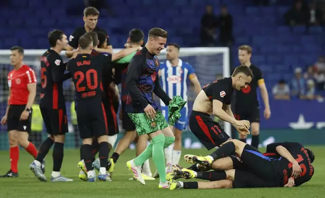 Barcelona players celebrate at the end of the Spanish La Liga soccer match between Barcelona and Espanyol at Lluis Companys Olympic Stadium in Barcelona, Spain, Thursday, May 15, 2025. (AP Photo/Joan Monfort)