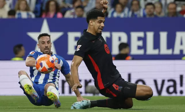 Espanyol's Edu Exposito, left, fights for the ball with Barcelona's Ronald Araujo during a Spanish La Liga soccer match between Barcelona and Espanyol at Lluis Companys Olympic Stadium in Barcelona, Spain, Thursday, May 15, 2025. (AP Photo/Joan Monfort)