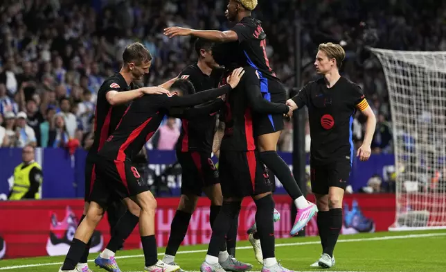 Barcelona players celebrate after a goal during a Spanish La Liga soccer match between Espanyol and Barcelona in Barcelona, Spain, Thursday, May 15, 2025. (AP Photo/Jose Breton)
