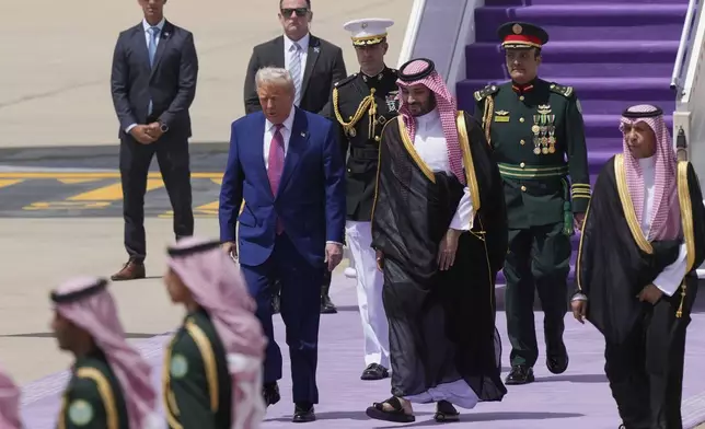 President Donald Trump walks with Saudi Crown Prince Mohammed bin Salman during an arrival ceremony at the Royal Terminal of King Khalid International Airport in Riyadh, Saudi Arabia, Tuesday, May 13, 2025