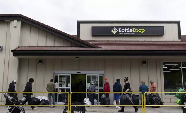 People wait in line outside the Glisan BottleDrop Redemption Center on Thursday, May 15, 2025, in Portland, Ore. (AP Photo/Jenny Kane)