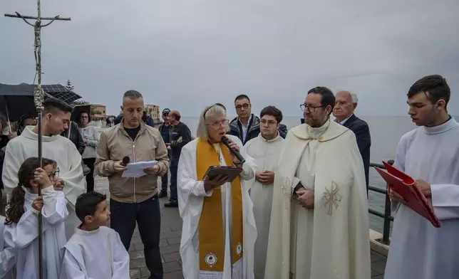 Deacon of the Church of England, Carrie Pemberton Ford, center, speaks, Sunday, May 4, 2025, after attending a Mass celebrated by Catholic priest, father Lorenzo Buscemi, second from right, in the Sicilian village of Porticello, southern Italy, for the victims of the British superyacht Bayesian which sank off Porticello, on Aug. 19, 2024. (AP Photo/Salvatore Cavalli)