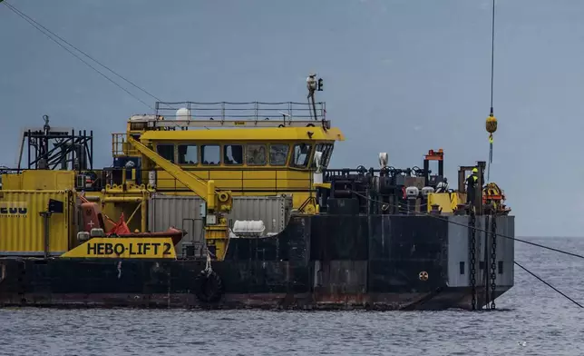 The multi-purpose floating work barge Hebo Lift 2 monitors the stretch of sea off Porticello, near Palermo, Sicily, Italy, Sunday, May 4, 2025, where the British superyacht Bayesian sunk on August 19, 2024 as the operations for its recovery start. (AP Photo/Salvatore Cavalli)