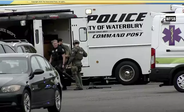 This still image made from video provided by WFSB-TV shows armed police officers and a police truck outside of the Brass Mill Center in Waterbury, Conn., May 27, 2025. (WFSB-TV via AP)