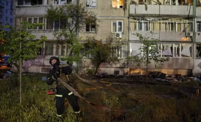 A firefighter works on the site of a residential building damaged after a Russian attack in Kyiv, Ukraine, Saturday, May 24, 2025. (AP Photo/Alex Babenko)