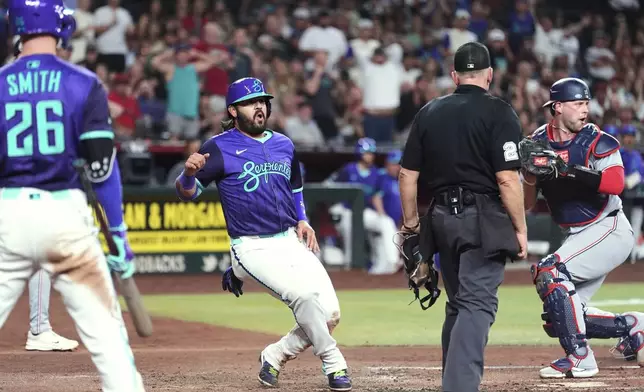 Arizona Diamondbacks' Eugenio Suárez, second from left, is tagged out at home plate by Washington Nationals catcher Riley Adams, right, as home plate umpire Lance Barksdale and Diamondbacks' Pavin Smith (26) look on during the third inning of a baseball game Friday, May 30, 2025, in Phoenix. (AP Photo/Ross D. Franklin)