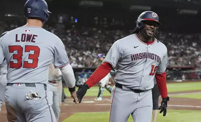 Washington Nationals' Josh Bell, right, smiles as he celebrates his three-run home run against the Arizona Diamondbacks with Nationals' Nathaniel Lowe (33) during the third inning of a baseball game Friday, May 30, 2025, in Phoenix. (AP Photo/Ross D. Franklin)