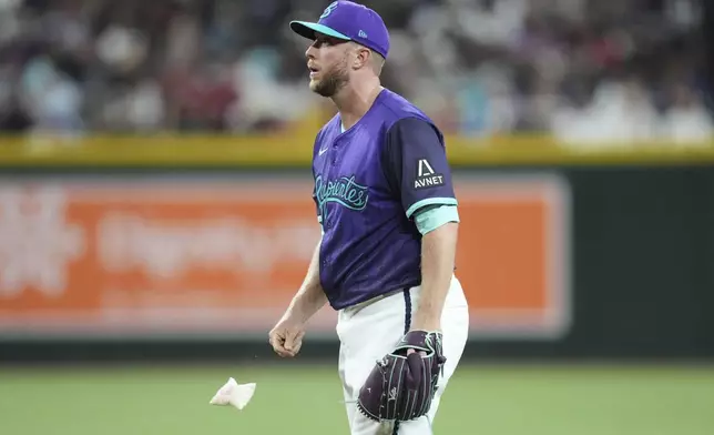 Arizona Diamondbacks starting pitcher Merrill Kelly tosses the rosin bag after giving up a triple to Washington Nationals' José Tena during the third inning of a baseball game Friday, May 30, 2025, in Phoenix. (AP Photo/Ross D. Franklin)