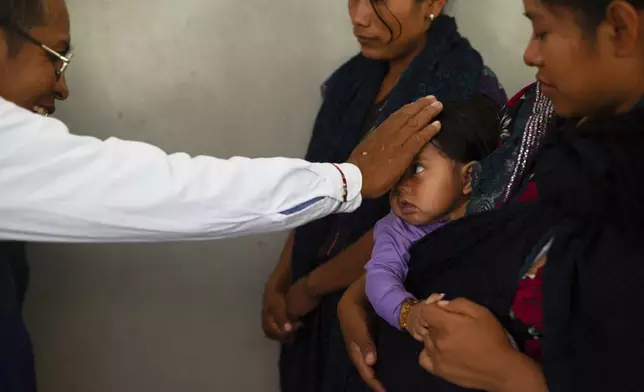 Deacon Juan Pérez Gómez bestows a blessing on a child during a Mass honoring the late Pope Francis in the Simojovel municipality, Mexico, Sunday, April 27, 2025. (AP Photo/Isabel Mateos)