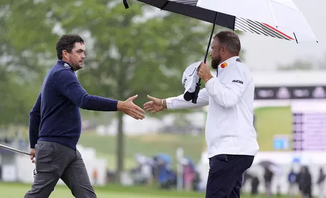 Keegan Bradley, left, and Shane Lowry, of Ireland, shake hands after the second round of the Truist Championship golf tournament at the Philadelphia Cricket Club, Friday, May 9, 2025, in Flourtown. (AP Photo/Matt Rourke)