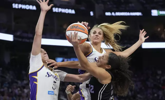 Golden State Valkyries guard Veronica Burton, bottom right, shoots against Los Angeles Sparks forward Dearica Hamby, left, and guard Sarah Ashlee Barker during the first half of a WNBA basketball game in San Francisco, Friday, May 16, 2025. (AP Photo/Jeff Chiu)