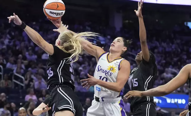 Los Angeles Sparks guard Kelsey Plum, middle, shoots against Golden State Valkyries guard Julie Vanloo (35) and guard Tiffany Hayes (15) during the second half of a WNBA basketball game in San Francisco, Friday, May 16, 2025. (AP Photo/Jeff Chiu)