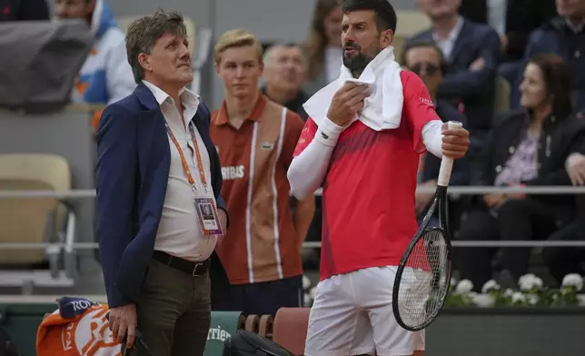 Serbia's Novak Djokovic talks with officials as he plays Mackenzie McDonald of the U.S. during their first round match of the French Tennis Open, at the Roland-Garros stadium, in Paris, Tuesday, May 27, 2025. (AP Photo/Thibault Camus)