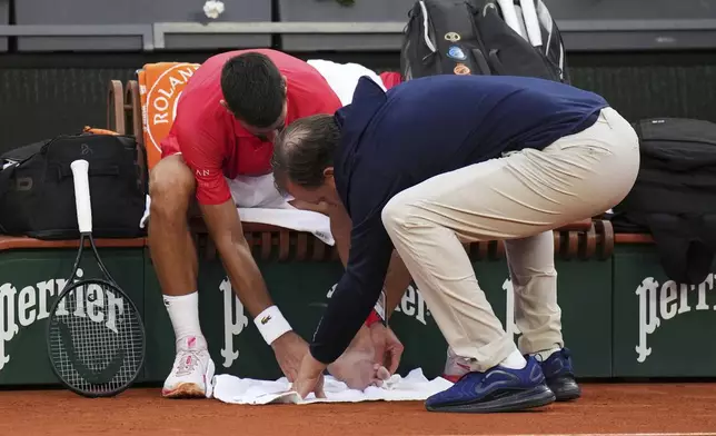 Serbia's Novak Djokovic receives medical assistance during his second round match of the French Tennis Open against France's Corentin Moutet, at the Roland-Garros stadium, in Paris, Thursday, May 29, 2025. (AP Photo/Christophe Ena)
