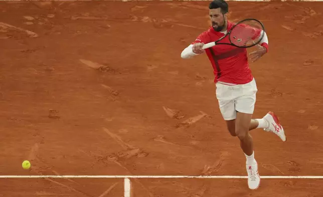 Serbia's Novak Djokovic returns the ball to Mackenzie McDonald of the U.S. during their first round match of the French Tennis Open, at the Roland-Garros stadium, in Paris, Tuesday, May 27, 2025. (AP Photo/Thibault Camus)
