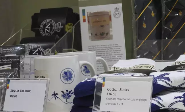 Socks are mugs printed with the biscuit tin pattern and label are seen for sale in the New Zealand Parliament gift shop in Wellington, New Zealand, Thursday, May 22, 2025. (AP Photo/Charlotte Graham-McLay)