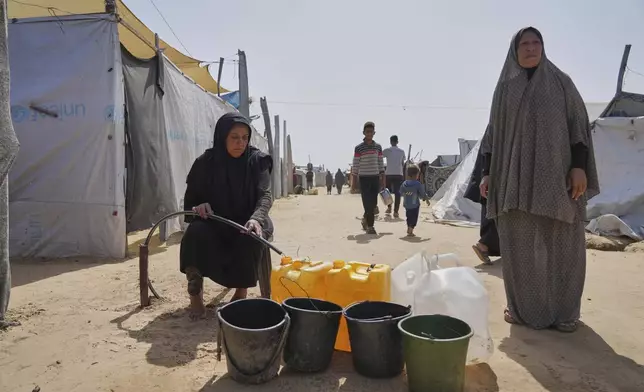 Displaced Palestinians fill jerrycans with water from a pipe at a tent camp in Khan Younis, Gaza Strip, on Sunday, May 11, 2025. (AP Photo/Abdel Kareem Hana)