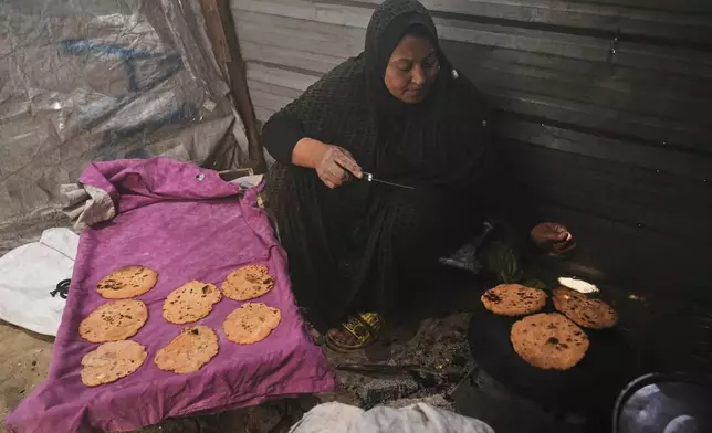 Nevin Qassim, a displaced Palestinian woman, prepares ground lentil dough as a substitute for bread due to a shortage of flour in the Gaza Strip, in Khan Younis, on Sunday, May 11, 2025. (AP Photo/Abdel Karem Hanna)