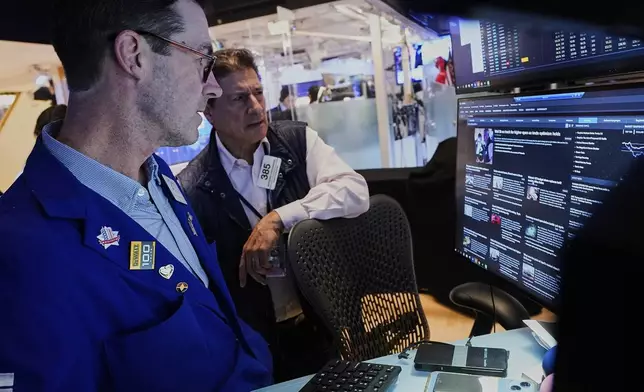 Specialist John McNierney, left, and trader Anthony Carannante work on the floor of the New York Stock Exchange, Wednesday, May 14, 2025. (AP Photo/Richard Drew)