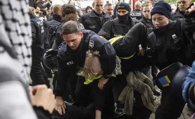 Police officers detain a participant at a pro-Palestinian demonstration to mark the 77th Nakba Day, in Berlin, Germany Thursday May 15, 2025. (Christophe Gateau/dpa via AP)