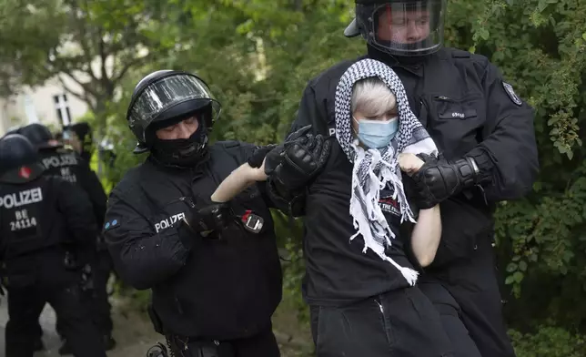 Police officers detain a participant at a pro-Palestinian demonstration to mark the 77th Nakba Day, in Berlin, Germany Thursday May 15, 2025. (Christophe Gateau/dpa via AP)