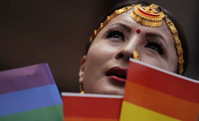 FILE—In this Aug. 16, 2019 file photo, a participant holds a rainbow flag before a gay pride parade in Kathmandu, Nepal. (AP Photo/Niranjan Shrestha, File)