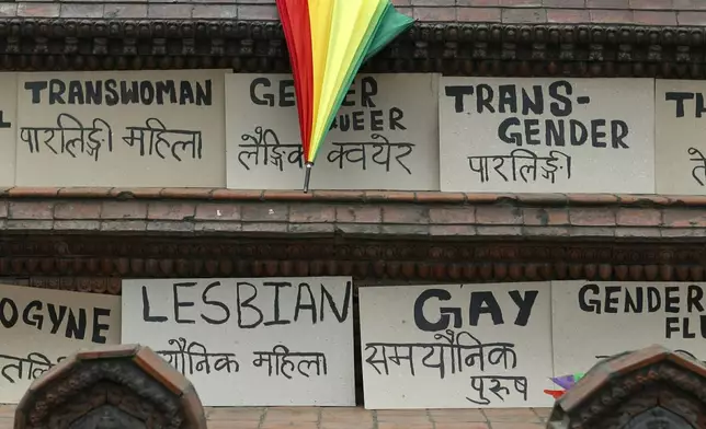 FILE—In this June 29, 2019 photo, an umbrella in the colors of the rainbow lies near placards meant for a pride parade to mark pride month in Kathmandu, Nepal. (AP Photo/Niranjan Shrestha, File)