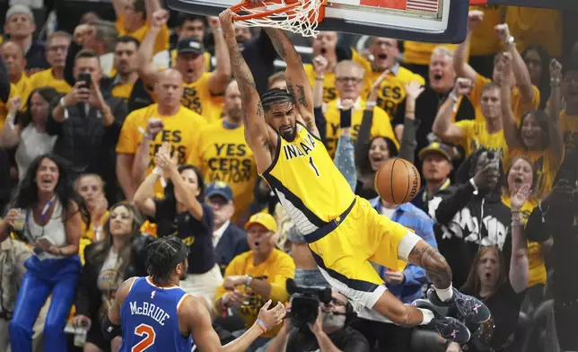 Indiana Pacers forward Obi Toppin (1) dunks the ball over New York Knicks guard Miles McBride (2) during the first half of Game 4 of the Eastern Conference finals of the NBA basketball playoffs in Indianapolis, Tuesday, May 27, 2025. (AP Photo/Michael Conroy)