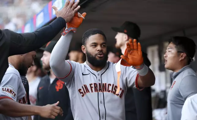 San Francisco Giants outfielder Heliot Ramos (17) celebrates in the dugout after hitting a home run during the second inning of a baseball game against the Minnesota Twins Saturday, May 10, 2025, in Minneapolis. (AP Photo/Ellen Schmidt)
