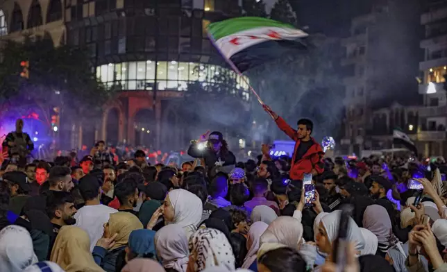 Syrians celebrate after U.S. President Donald Trump announced plans during his visit to Saudi Arabia to ease sanctions on Syria and normalize relations with its new government, in Homs, Syria, late Tuesday, May 13, 2025.(AP Photo/Omar Albam)