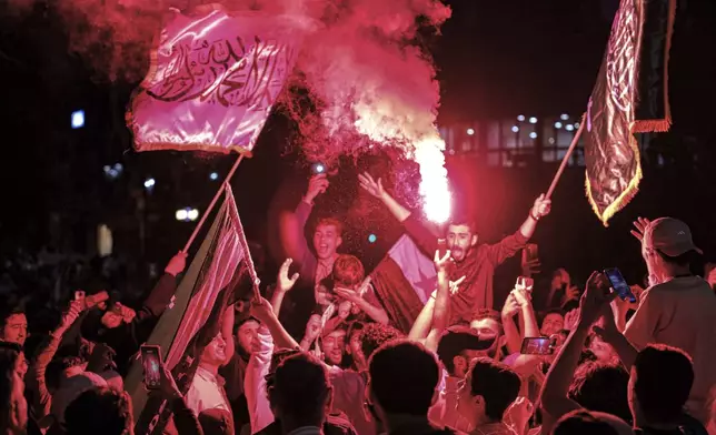 Syrians wave Saudi and Syrian flags in celebration after U.S. President Donald Trump announced plans during his visit to Saudi Arabia to ease sanctions on Syria and normalize relations with its new government, in Homs, Syria, late Tuesday, May 13, 2025.(AP Photo/Omar Albam)