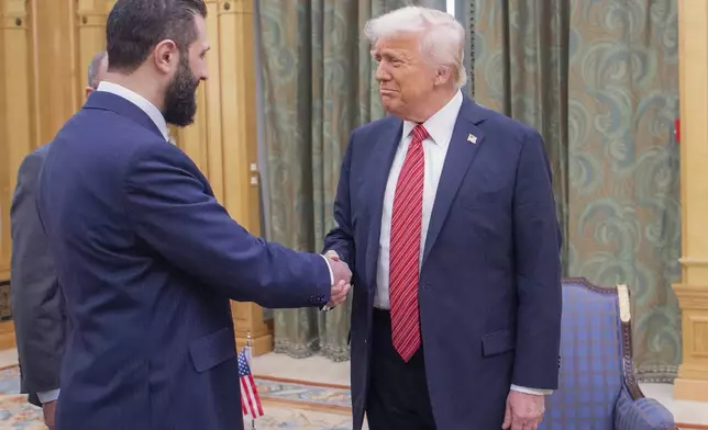 In this photo released by the Saudi Royal Palace, President Donald Trump, right, shakes hands with Syria's interim President Ahmad al-Sharaa, in Riyadh, Saudi Arabia, Wednesday, May 14, 2025. (Bandar Aljaloud/Saudi Royal Palace via AP)