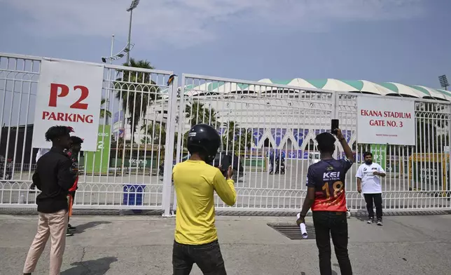 Fans take pictures outside the closed entrance of Atal Bihari Vajpayee Ekana Cricket Stadium after organizers suspended the Indian Premier League for one week following the escalating military tensions with Pakistan, in Lucknow, India, Friday, May 9, 2025. (AP Photo)