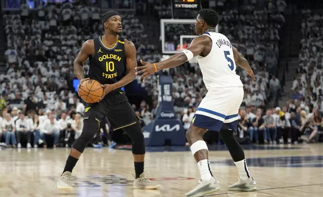 Golden State Warriors forward Jimmy Butler (10) handles the ball as Minnesota Timberwolves guard Anthony Edwards (5) defends during the first half of Game 1 of an NBA basketball second-round playoff series, Tuesday, May 6, 2025, in Minneapolis. (AP Photo/Abbie Parr)