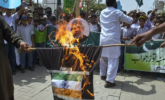 Supporters of Jamaat-e-Islami burn an effigy of Indian Prime Minister Narendra Modi with Indian flag during a demonstration to condemn Indian strikes in Pakistan and to show their support for Pakistan military, in Karachi, Pakistan, Friday, May 9, 2025. (AP Photo/Fareed Khan)
