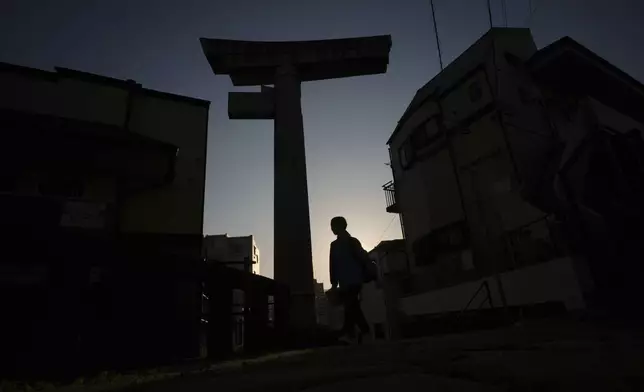 A person walks past the One-Pillar Torii Gate at Sannō Shrine, the only gate remaining of four gates after the 1945 atomic bombing in Nagasaki, southern Japan, Friday, April 25, 2025. (AP Photo/Eugene Hoshiko)