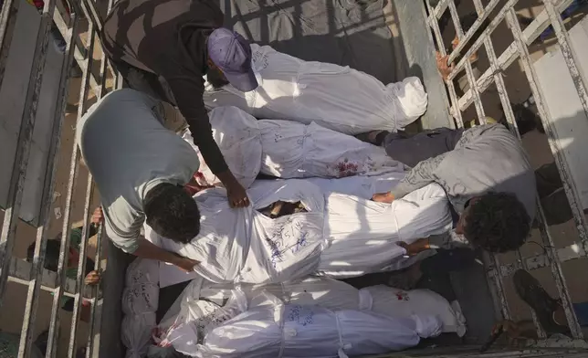Palestinians load bodies of their relatives killed in the Israeli army airstrikes in Jabalia, northern Gaza Strip, on Wednesday, May 14, 2025. According to local hospitals, 48 people were killed in the strikes, including 22 children. (AP Photo/Jehad Alshrafi)