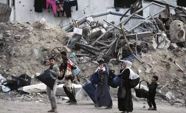 Palestinians evacuate after the Israeli army issued an evacuation warning for several schools and a hospital in Gaza City's Rimal neighborhood, Wednesday, May 14, 2025. (AP Photo/Jehad Alshrafi)