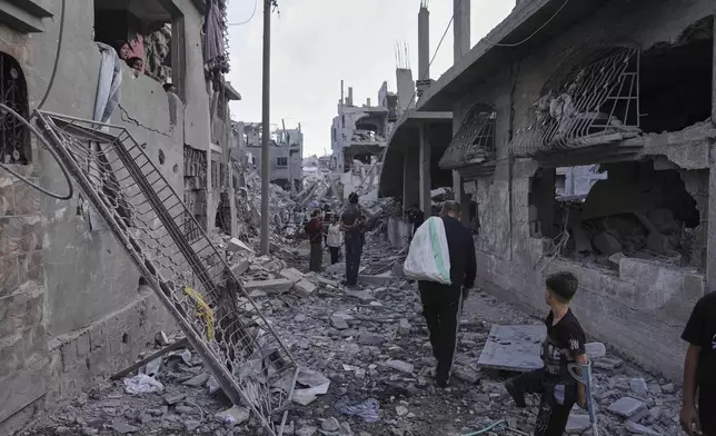 Palestinians inspect the rubble of homes destroyed by Israeli airstrikes in Jabalia, northern Gaza Strip, on Wednesday, May 14, 2025. According to local hospitals, 48 people were killed in the strikes, including 22 children. (AP Photo/Jehad Alshrafi)