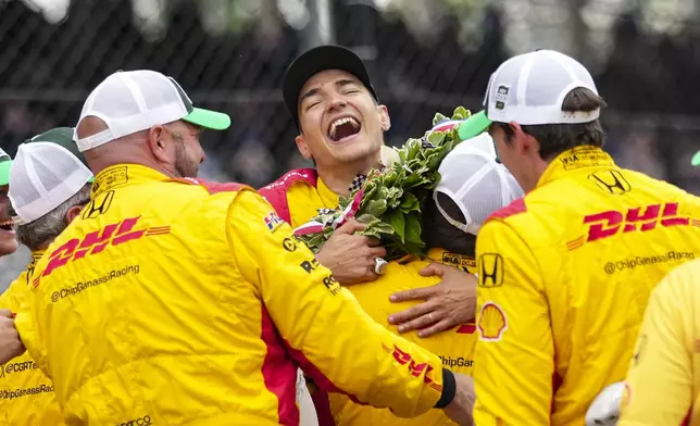 Alex Palou, center, of Spain, celebrates with his crew after winning the Indianapolis 500 auto race at Indianapolis Motor Speedway in Indianapolis, Sunday, May 25, 2025. (AP Photo/AJ Mast)