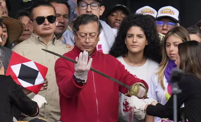 President Gustavo Petro holds a sword that once belonged to independence hero Simón Bolívar during a speech to supporters outside Congress in Bogotá, Colombia, Thursday, May 1, 2025, before presenting a referendum proposal on his labor reform to the Senate following two failed attempts in the legislature. (AP Photo/Fernando Vergara)