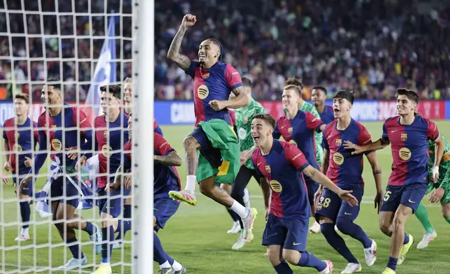 Barcelona's Raphinha, centre, celebrates with teammates as whey won the La Liga after the Spanish La Liga soccer match between Barcelona and Villarreal at Lluis Companys Olympic Stadium in Barcelona, Spain, Sunday, May 18, 2025. (AP Photo/Joan Monfort)