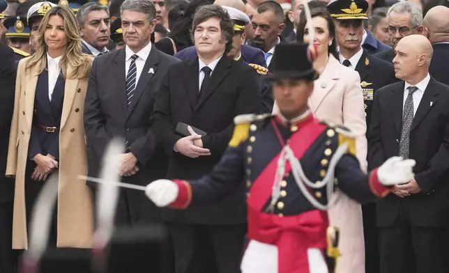 President Javier Milei, third from left, and members of his cabinet watch a parade marking the anniversary of the formation of Argentina's first independent government in Buenos Aires, Argentina, Sunday, May 25, 2025. (AP Photo/Gustavo Garello)