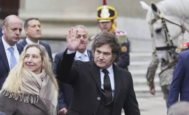 President Javier Milei waves after a Mass marking the anniversary of the formation of Argentina's first independent government, alongside his sister Karina, left, in Buenos Aires, Argentina, Sunday, May 25, 2025. (AP Photo/Gustavo Garello)