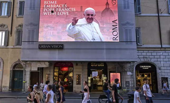 A street screen dedicated to Pope Francis reads "Rome hugs Francis with Love" in downtown Rome, Friday, May 2, 2025. (AP Photo/Bernat Armangue)