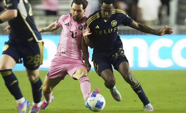 Inter Miami forward Lionel Messi, left, runs with the ball against Vancouver Whitecaps forward Ali Ahmed, right, during the first half of a CONCACAF Champions Cup second-leg semifinal soccer match, Wednesday, April 30, 2025, in Fort Lauderdale, Fla. (AP Photo/Lynne Sladky)