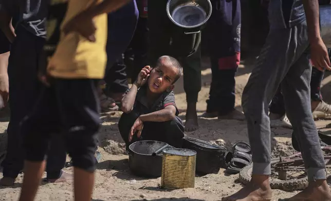 A Palestinian child rests while struggling to obtain donated food at a community kitchen in Khan Younis, in the southern Gaza Strip, Friday, May 9, 2025. (AP Photo/Abdel Kareem Hana)